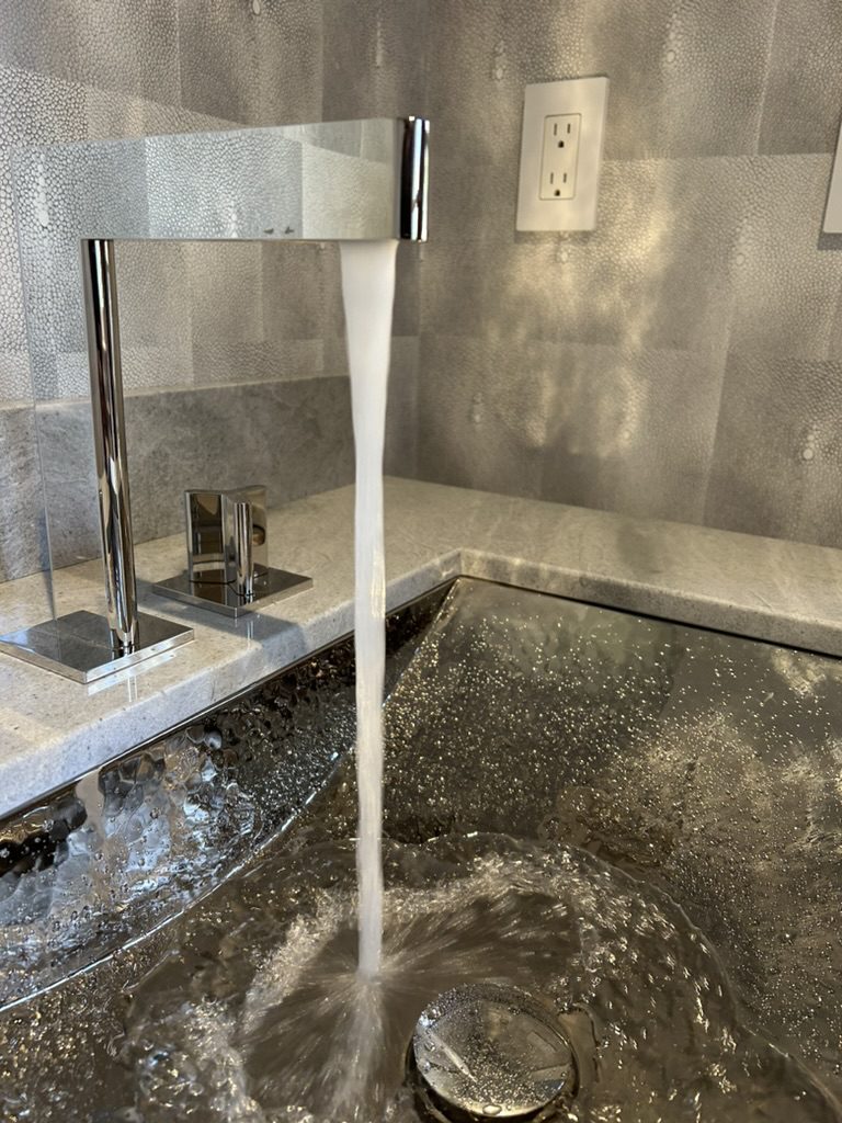 Modern bathroom faucet with water flowing into sink in Southington, CT — clean and stylish plumbing fixture installed by Charter Oak Plumbing.